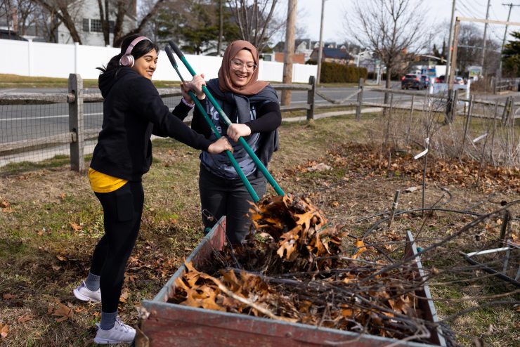 Panther Day of Service at - two students remove leaves for a community garden on campus.